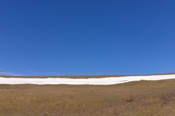 Fototapeta premium Smooth snow and blue sky in the mountains.