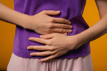 Young woman squeezing belly with hands. abdominal pain, suffering stomach ache