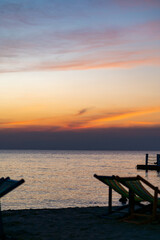 Silhouette of a chair at sunrise on a beautiful beach in Thailand.