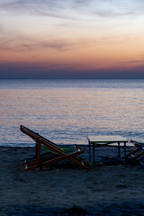 Silhouette of a chair at sunrise on a beautiful beach in Thailand.