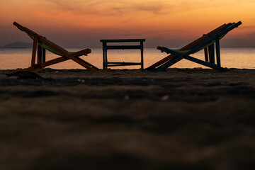 Silhouette of a chair at sunrise on a beautiful beach in Thailand.