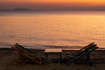 Silhouette of a chair at sunrise on a beautiful beach in Thailand.