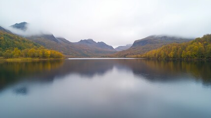 Fototapeta premium Misty Morning at Beautiful Lake with Mountains and Forest Reflections in Autumn