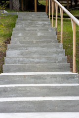A concrete staircase with a wooden railing
