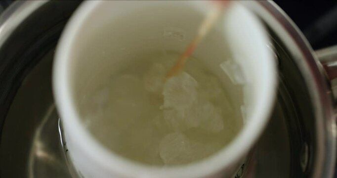 making organic homemade soap, melting base in steam bath, mixes the soap mass, top view