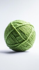 Fototapeta premium Soft green yarn ball on white surface