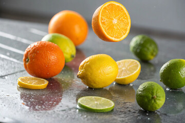 Oranges, lemons, and limes spinning and rolling on a sleek surface