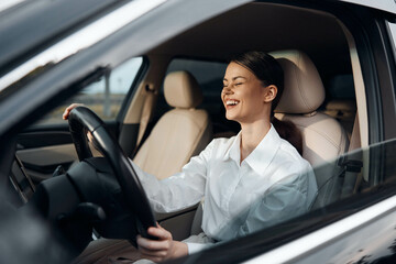 Woman, car, driver, smile a cheerful woman with a radiant smile sits confidently in the driver's...