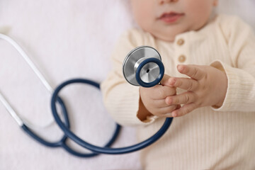 Little child with stethoscope on towel, top view. Checking baby's health
