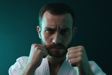 Karate fighter wearing uniform in color lights, closeup