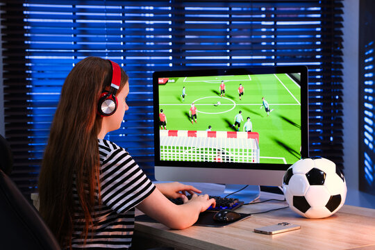 Girl playing video game with keyboard at table indoors