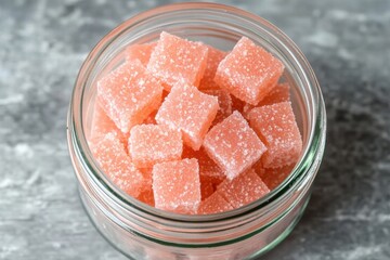 Pink Sugary Cubes in Glass Jar on Gray Background