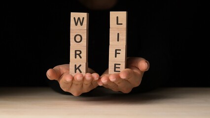 A close-up view symbolizing a personal wellbeing strategy, A woman's hands hold wooden blocks...