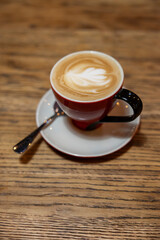 A cup of cappuccino on a rustic oak table. Shallow depth of field.