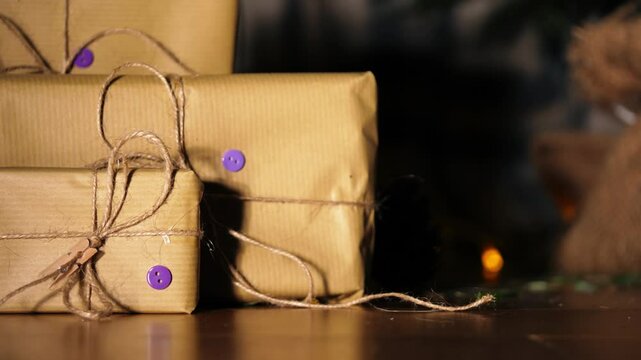 Gift wrapped in brown paper and string with Christmas lights bokeh background
