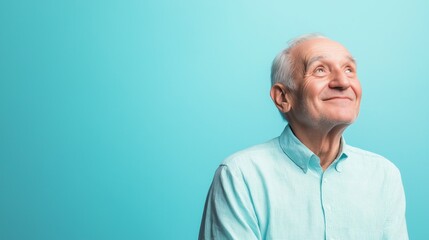 Fototapeta premium Elderly Man Smiling Against Blue Background