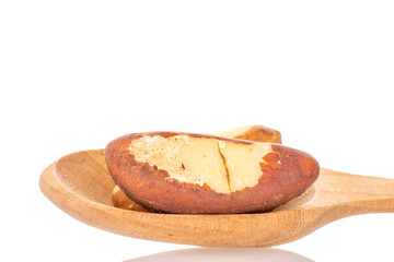 Several Brazil nuts with a wooden spoon, close-up, isolated on a white background.