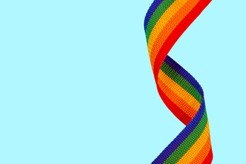 LGBT rainbow ribbon pride symbol on mint background.
Equality between homosexuals and heterosexuals concept.
LGBTQIA+ community. (lesbian , gay , bisexual ,transgender ,transsexual)
Copy space.