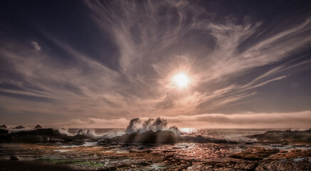 Crashing waves, dramatic sky, at low tide on Weston Beach, Point Lobos State Reserve. Panoramic view