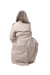 back view of a woman squatting and looking up on white background