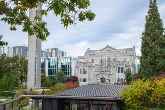 Vancouver, CANADA - Sep 30 2024 : Scenic view of UBC's Irving K. Barber Learning Centre featuring Gothic architecture, a tall clock tower, modern glass buildings, and lush greenery.