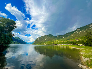Serene Lake Idro Surrounded by Majestic Mountains and Cloudy sky, Italy, Crone
