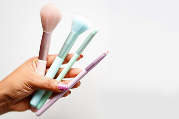 closeup of make up brushes in hand