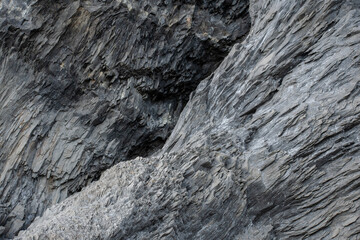 close up black volcanic rock formation in Iceland. Steep cliff rock formation.