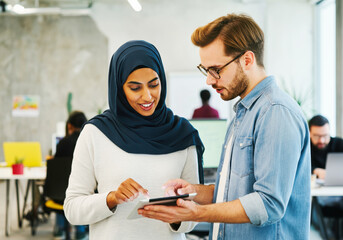 Caucasian male and asian female professionals collaborating in office setting