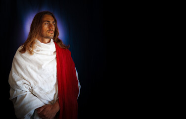 A handsome, bearded holy man in a white robe, horizontal format, with violet light surround, looks lovingly