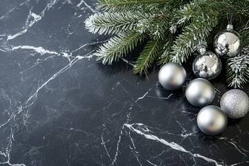 Silver Christmas ornaments and frosted pine branch on a dark marble background.