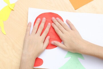 Girl making art project at table indoors, above view