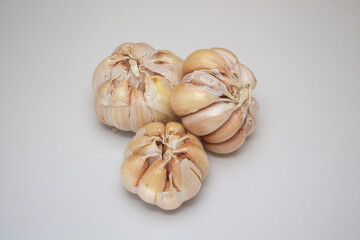 Close up of three cloves of garlic isolated on a white background.