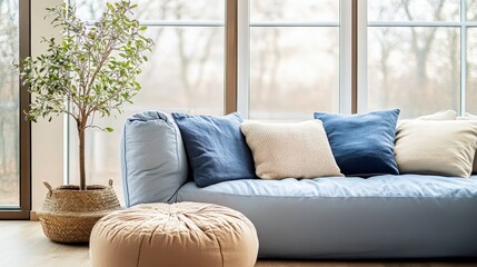 Cozy living room, large windows, natural light, potted tree, comfortable blue sofa, woven basket, throw pillows, minimalist interior, Scandinavian design, soft textures, tranquil atmosphere, muted col