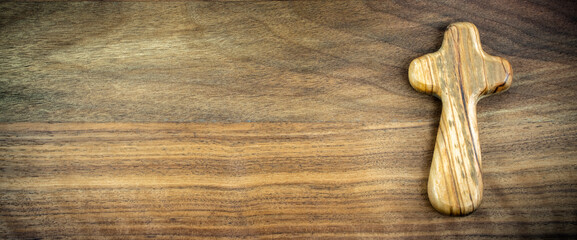 Wooden cross on wooden brown background - Concept of Easter or religious background with negative space