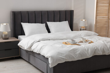 Breakfast tray on bed with beautiful linens indoors