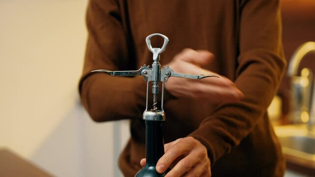 How to open a wine bottle using a corkscrew in a kitchen setting