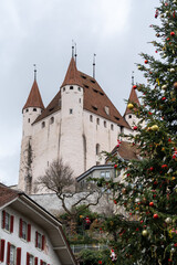 Schloss Thun Castle is a medieval castle in Thun. A city in the Bern Canton - Switzerland. Overcast winter day, Christmas tree in foreground