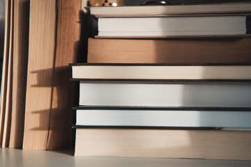 Old stacked books on shelf, reading and literature background, brown and light academia aesthetic