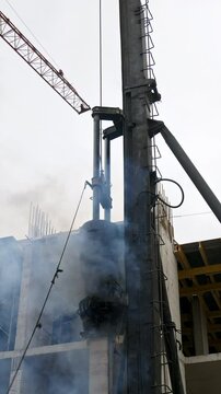 Pile Driver on Construction Site with Crane and Rebar