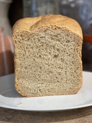 White Sandwich Bread Loaf Cut in Half, on a White Glass Plate on a Kitchen Counter.