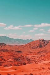 Dramatic desert landscape with red sand dunes and distant mountains under a vibrant blue sky.