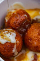 round spherical donuts with sweet caramel syrup street food close up