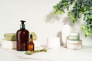 Bath background, beauty products in the bath shielf on white background. Cream, mask, soap, jade roller and face serum. © nadianb