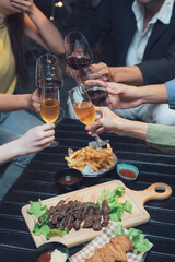 Cheers to Good Times: A group of friends raise their glasses in a toast, enjoying delicious food and drinks at a cozy outdoor setting.