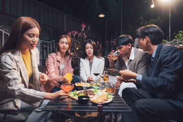 Nighttime Rendezvous: Friends enjoying drinks and appetizers at an outdoor restaurant. The warm lighting creates a relaxed, social atmosphere. 