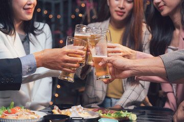 Cheers to Friendship: A group of friends raise their beer glasses in a toast, their faces illuminated by the warm glow of a dimly lit restaurant.