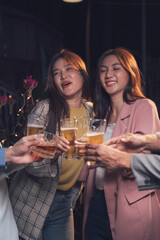 Cheers to Camaraderie: A group of friends clink glasses in a celebratory toast, their laughter echoing through the warm, inviting atmosphere of a dimly lit bar.
