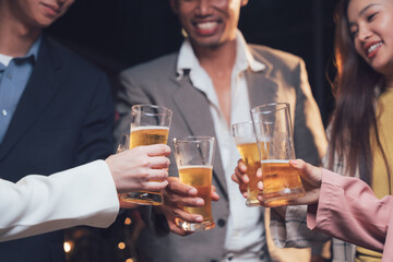 Cheers to Success: A toast to camaraderie and celebration, with four diverse individuals raising glasses of beer in a warm, dimly lit setting. Their smiles and raised glasses radiate a sense of joy.