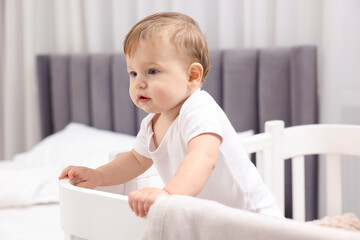 Cute little baby in crib at home